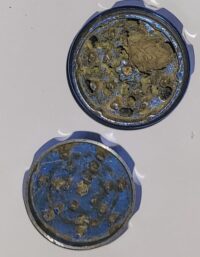 Grinder open showing unground cannabis flower