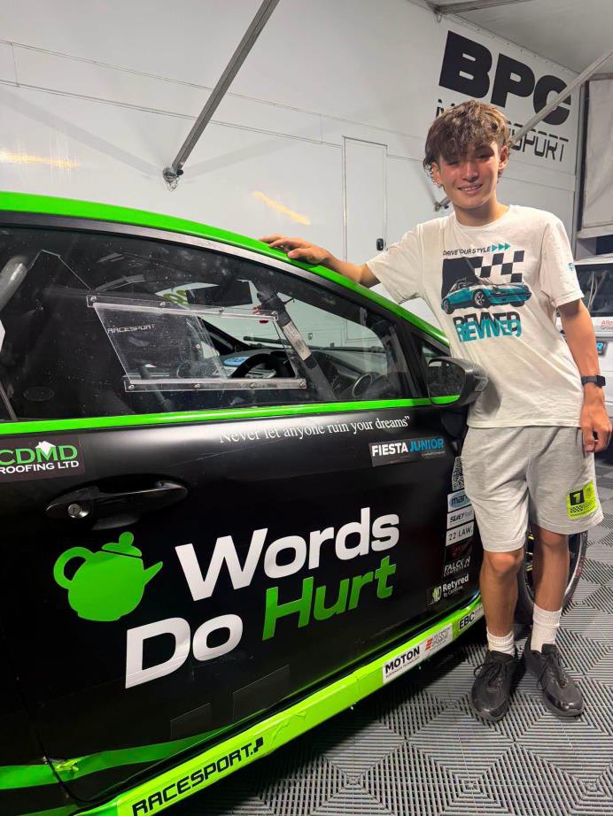 Thomas Potter standing beside his green Words Do Hurt race car