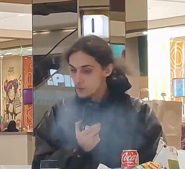 The author using a prescribed medical cannabis vaporiser while seated in a food court.